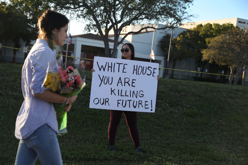 Karissa Saenz, a senior at Marjory Stoneman Douglas High School holds a sign in Parkland, Florida. Police arrested and charged 19 year old former student Nikolas Cruz for the February 14 shooting that killed 17 people.
Photo by Joe Raedle/Getty Images.