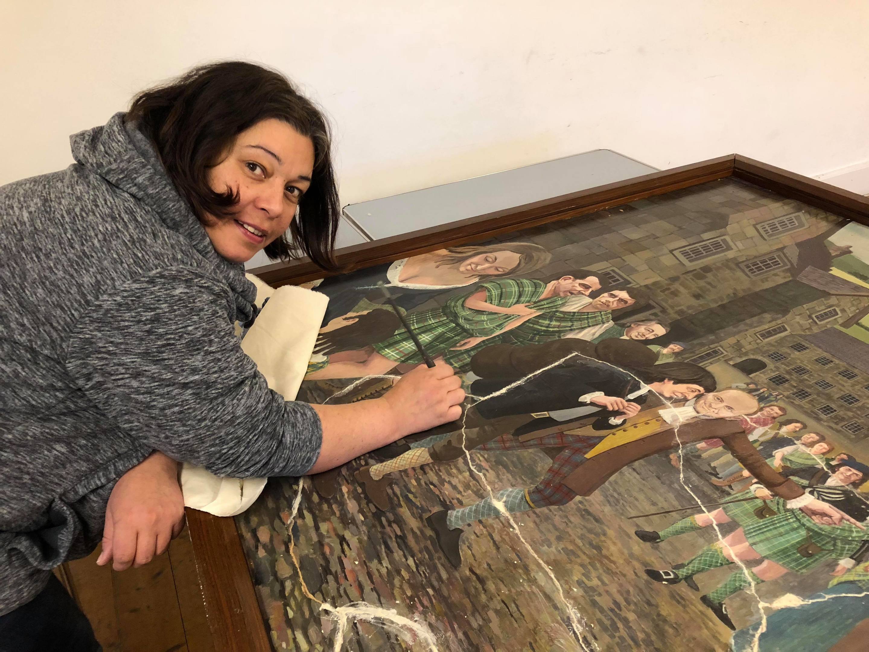 Artist Aneliya Beaton puts the damaged parts of the painting back together