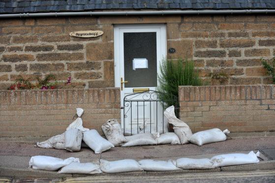 Cleaning up after previous flooding at Forsyth Street, Hopeman, Moray