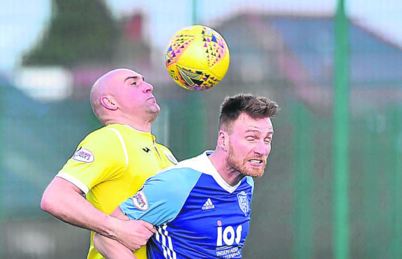 PETERHEAD'S RORY MCALLISTER IS HELD BY PAT SCULLION