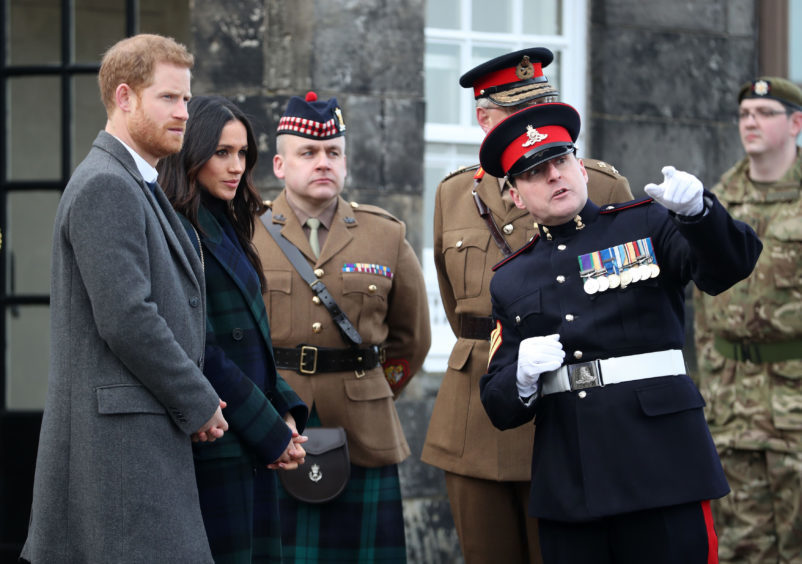 Prince Harry and Meghan Markle meet Sgt David Beveridge (right) before he fires the One o'clock gun at Edinburgh Castle