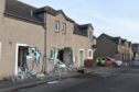 A construction tractor crashed into a sheltered housing complex, leaving a path of destruction behind.