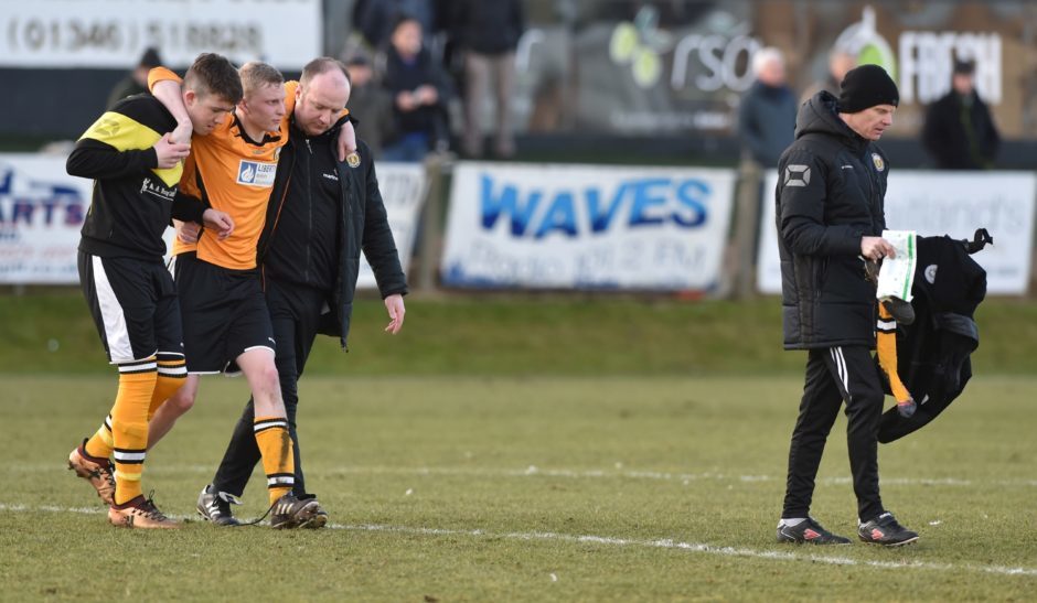 Battered and bruised - Fort William managers Ali Smoith and Paul MacLellan (right) with Ronan Cameron being helped off the field.