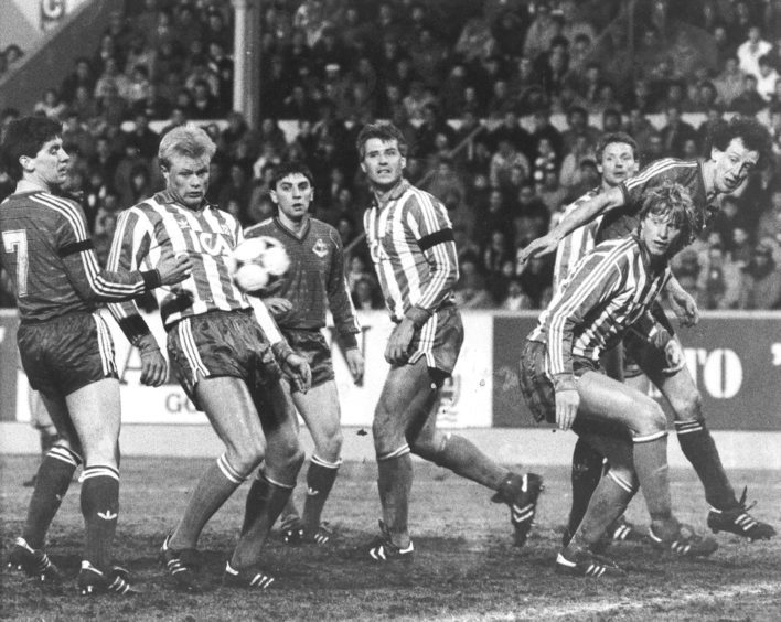 An anxious moment in the Gothenburg defence as this cross goes across the front of the goal. Dons players Stark, Hewitt and Black look on.