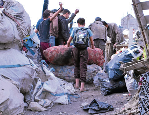 Kids in among metal waste vying for scraps to sell