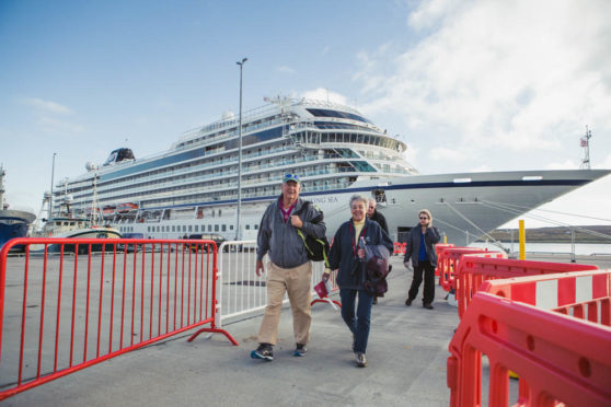 Tourists disembark from the cruise ship MV Columbus during her maiden call at Lerwick Harbour