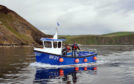 Iain West, deputy harbour master of Gardenstown and his boat  Explorer
