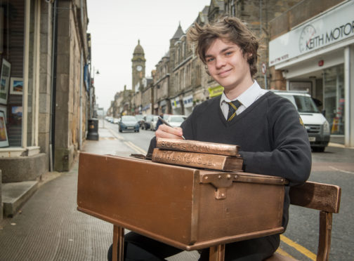 Harry Duncan from Keith Grammar School sitting at a mock-up of one of the potential designs