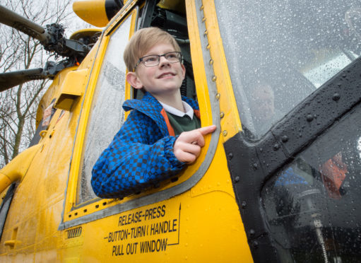 Calum Macpherson in the pilot seat of a Sea King helicopter.