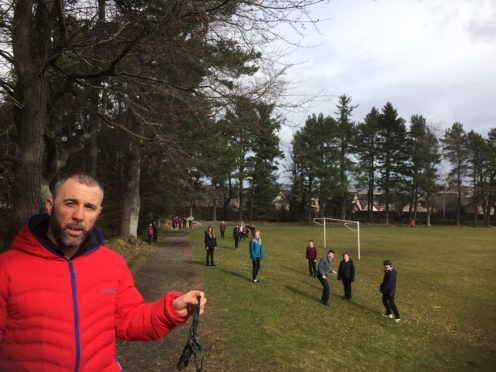 Class teacher Derek Gray with his pupils who are all standing next to a area containing dog mess