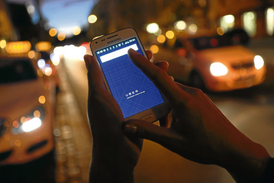 In this photo illustration, a woman uses the Uber app on an Samsung smartphone on September 2, 2014 in Berlin, Germany. Uber, an app that allows passenger to buy rides from drivers who do not have taxi permits, has had its UberPop freelance driver service banned in Germany after a complaint by Taxi Deutschland, a trade association of taxi drivers in the country. The company, which operates in 42 countries over 200 cities worldwide, plans to both appeal the decision made by a court in Frankfurt as well as, at the risk of heavy fines, continue its services in Germany until a final decision has been made on the matter.