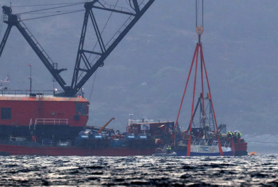 The Nancy Glen fishing trawler sits alongside a barge on Loch Fyne in Tarbert, Scotland, after its recovery.