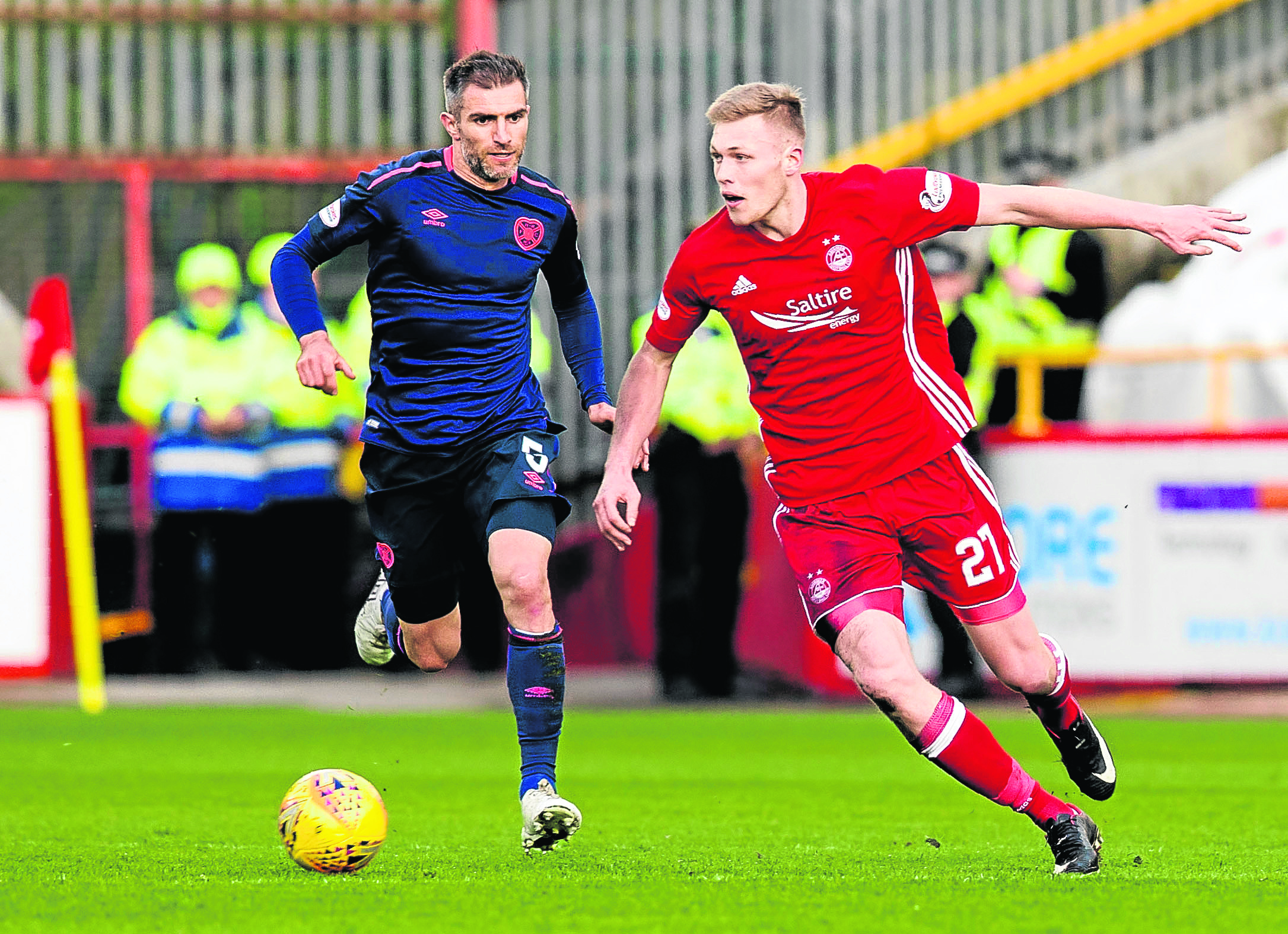 Aberdeen's Sam Cosgrove (right) skips away from Hearts' Aaron Hughes