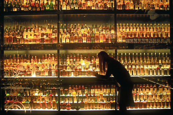 A member of staff looks at the Diageo Claive Scotch Whisky collection the worlds largest collection of Scotch whisky with 3,5000 individual bottles the collection is on display at the Scottish Whisky Experience near Edinburgh Castle.
