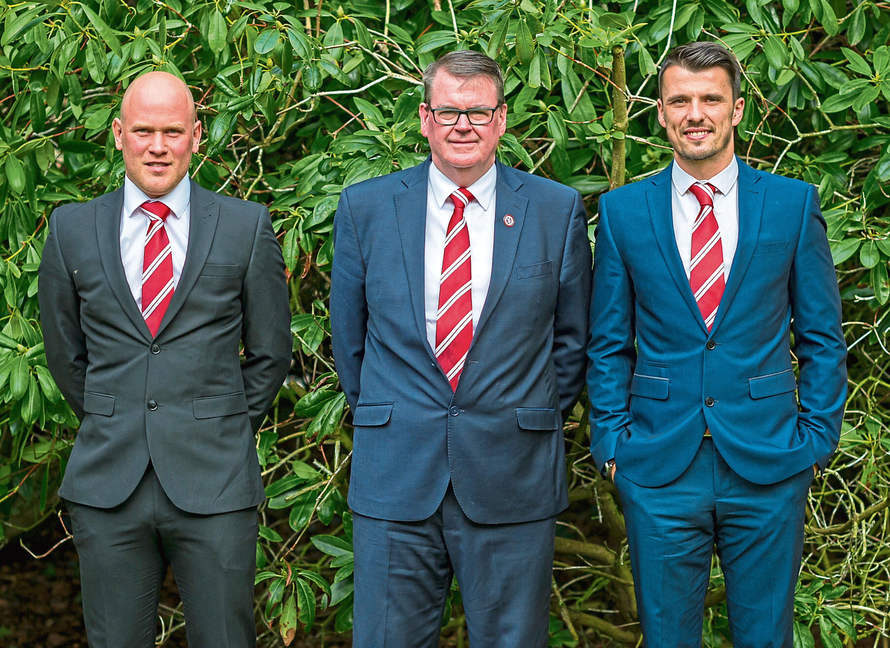 Brora coach Craig Campbell, Powrie and manager Steven Mackay.