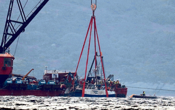 The Nancy Glen trawler sits alongside a barge on Loch Fyne following its recovery after sinking on January 18, with two men lost