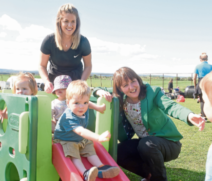 Maree Todd, right, with nursery practitioner Nicola Johnstone looking on as children take turns on a chute. Photograph by Sandy McCook