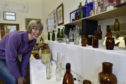 Doric Neuk founder Hannah Pennig inspects the bottles