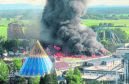 A black column of smoke rises from a warehouse in flames above the amusement park 'Europapark' in Rust,