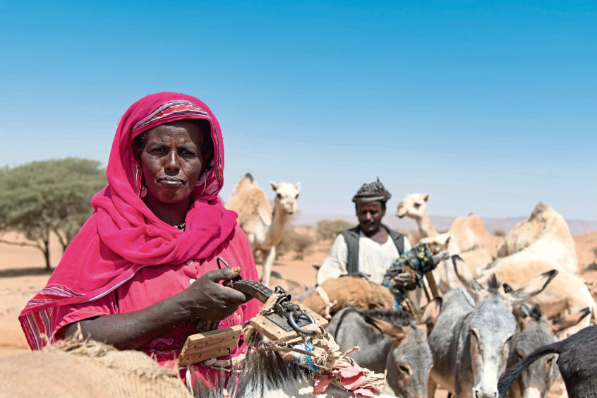 A nomadic woman collecting water from a well in the desert