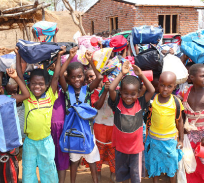 Children receiving backpacks from the Mary's Meals Foundation