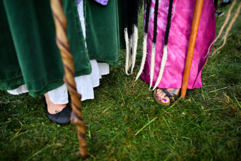 People carry staffs at Stonehenge where a crowd celebrated the dawn of the longest day in the UK. Photo: Ben Birchall/PA Wire