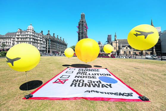 A protest against a proposed third runway at Heathrow Airport outside the Houses of Parliament ahead of the vote