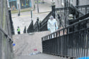 A forensic officer catalogues the scene on stairs leading to The Green, Union Street, Aberdeen.