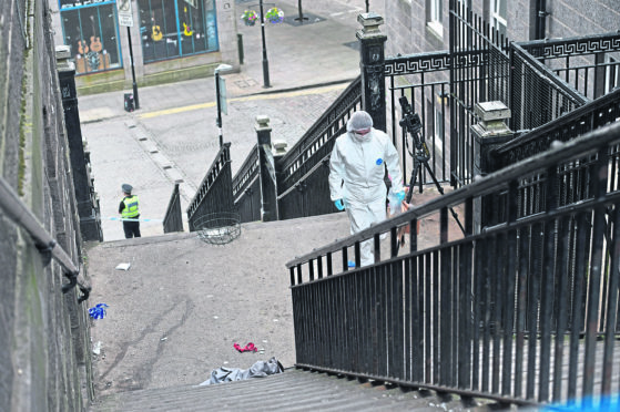 A forensic officer catalogues the scene on stairs leading to The Green, Union Street, Aberdeen.