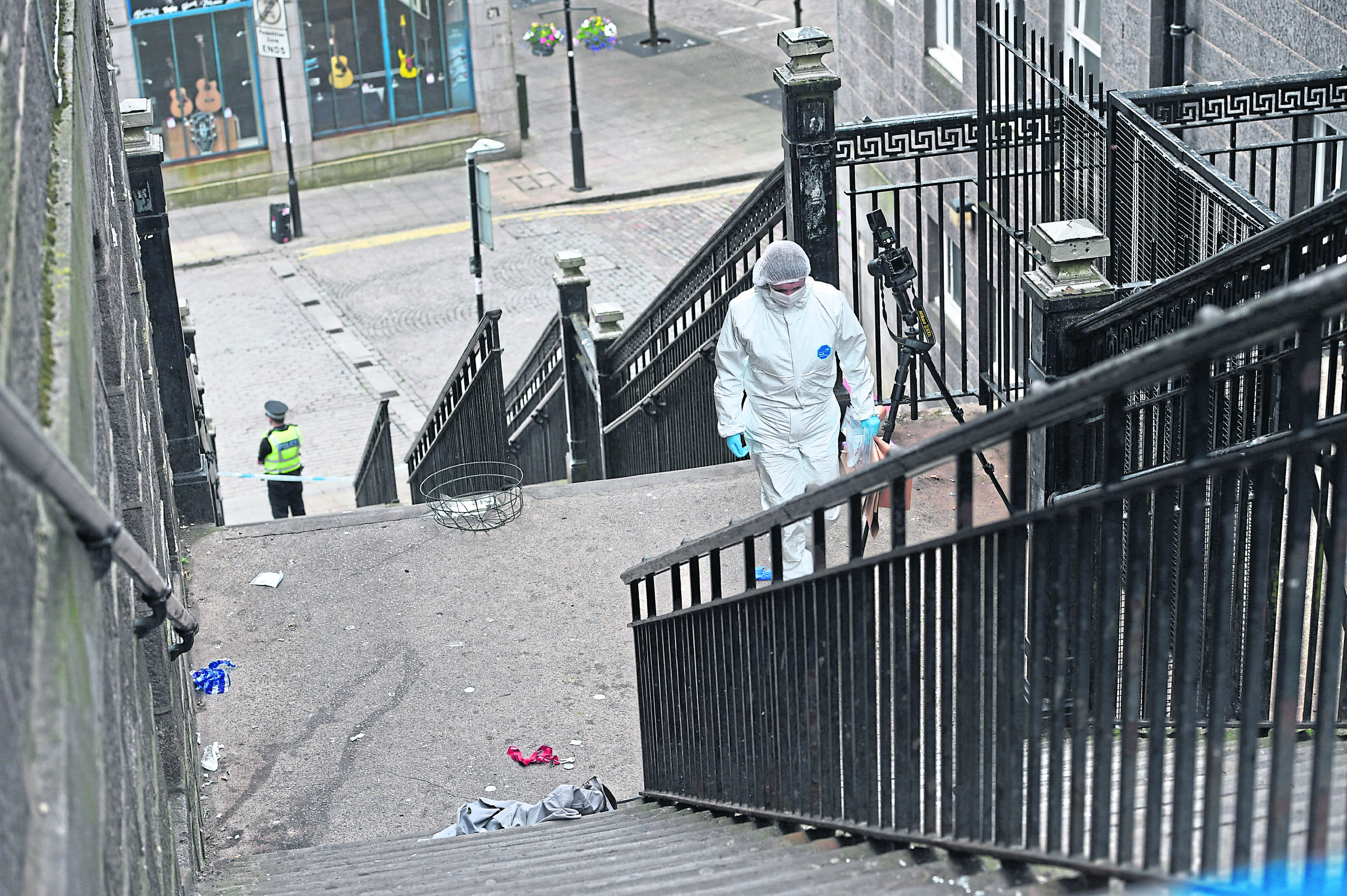 A forensic officer catalogues the scene on stairs leading to The Green, Union Street, Aberdeen.