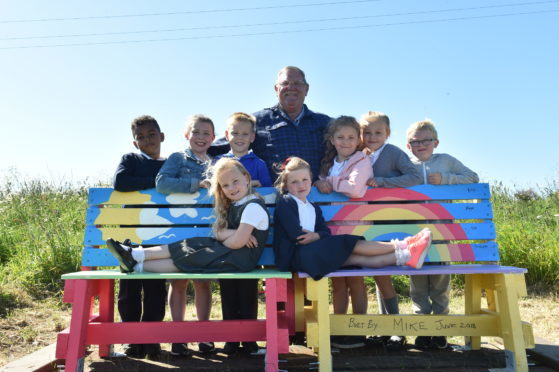 Mike Duncan with children at the new bench on the Cove Woodland Walk.