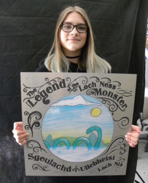 Millburn pupil Anna-Evalina holding the prototype for the HighlandAR Nessie plaque