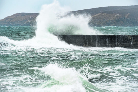 Waves crash against the a sea wall in Sandend, Moray on a very wet, freezing and windy day
Picture by Jason Hedges