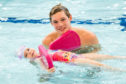 A young swimmer receives swimming lessons from Commonwealth athlete Duncan Scott