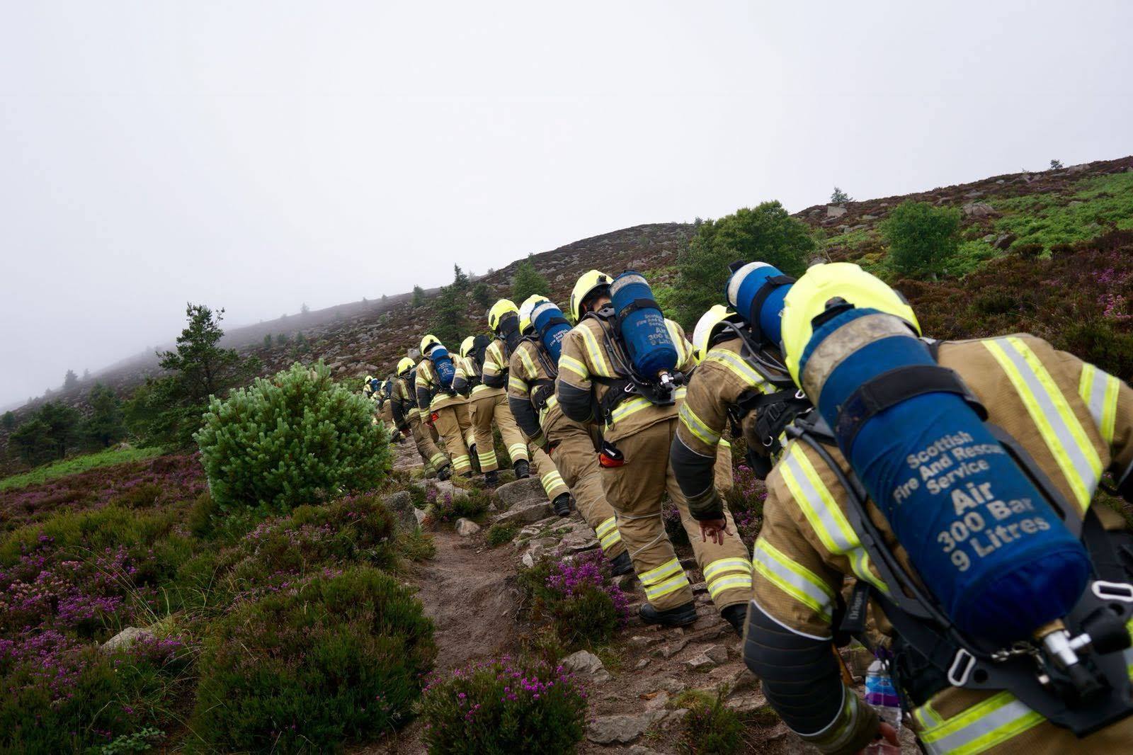 The trainee firefighters scaling Bennachie hill in Aberdeenshire.