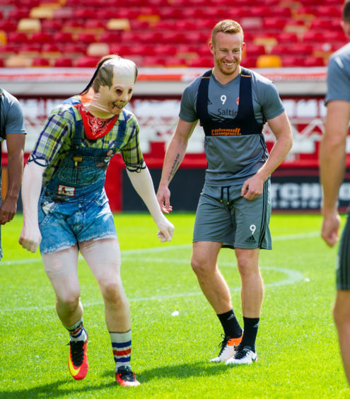 Rooney (centre) laughs at team mate Wes Burns (right) during training in August 2016.