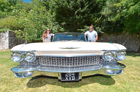 Gina and Keith Stewart with a 1960 Cadillac, which comes in at almost 7ft wide and 20ft long.