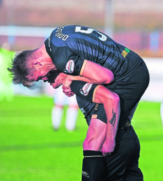 Tom Walsh celebrates one of his two goals by giving Caley Thistle team-mate Coll Donaldson a lift last night