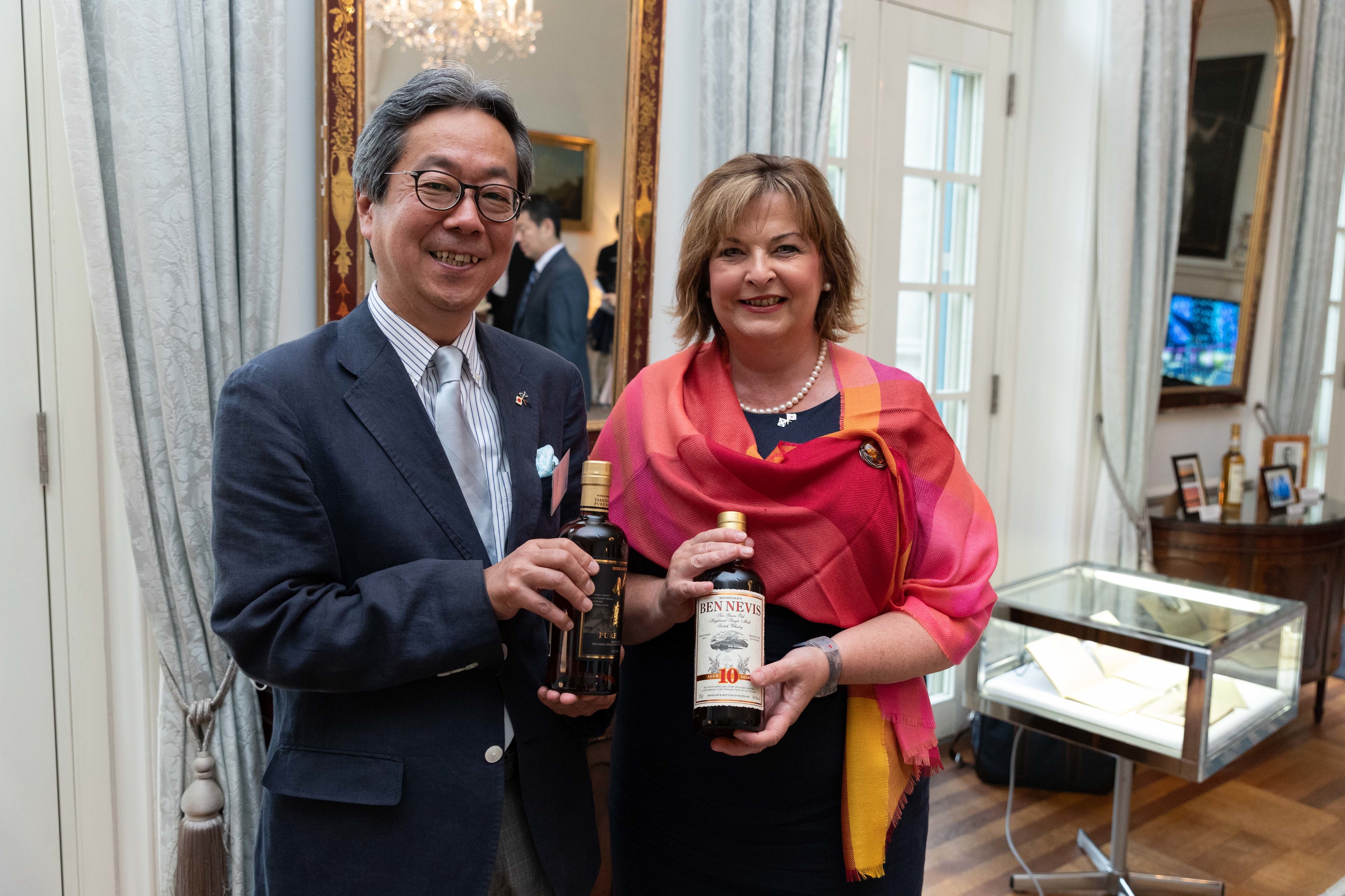 Fiona Hyslop, holding a bottle of Ben Nevis with Nikka Whisky master blender Tadashi Sakuma.
