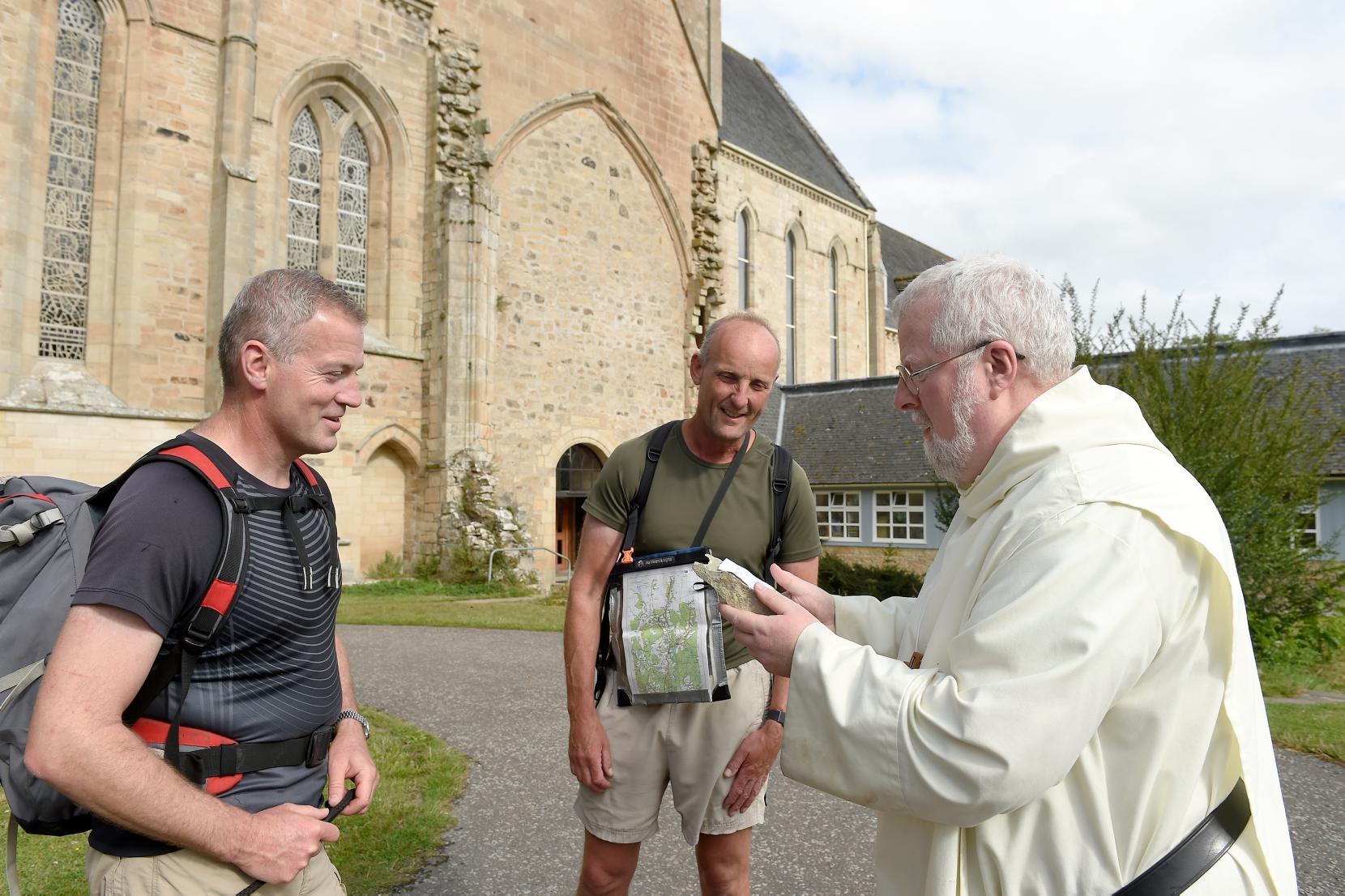 Pilgrims Andy Wallis (left) and Alistair Monkman (right) are greeted at Pluscarden Abbey last night by Abbot Anselm