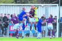 Hearts goalkeeper Zdenek Zlamal punches clear under pressure during this Cove Rangers attack at Balmoral Stadium