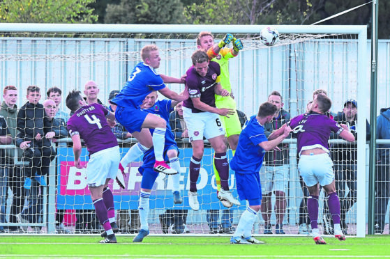 Hearts goalkeeper Zdenek Zlamal punches clear under pressure during this Cove Rangers attack at Balmoral Stadium