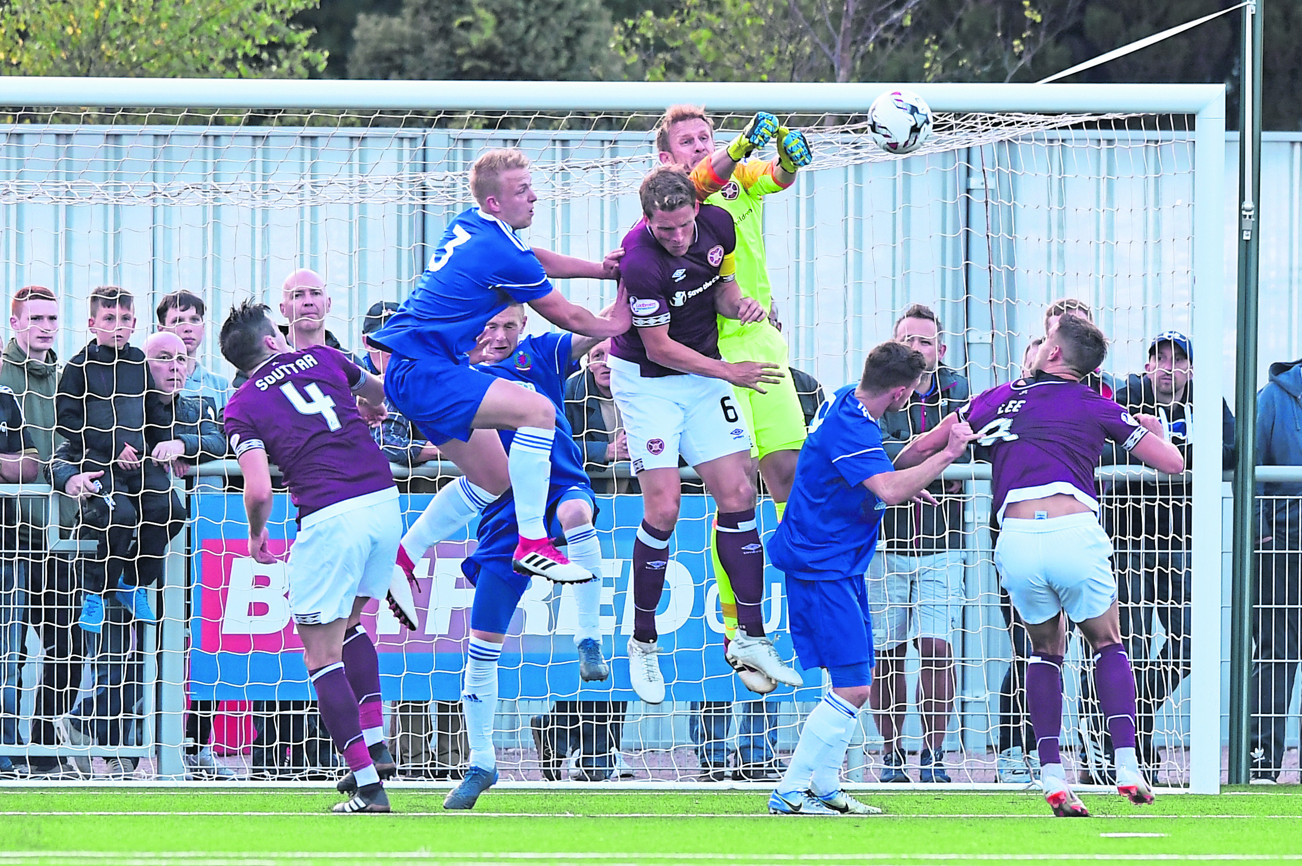 Hearts goalkeeper Zdenek Zlamal punches clear under pressure during this Cove Rangers attack at Balmoral Stadium