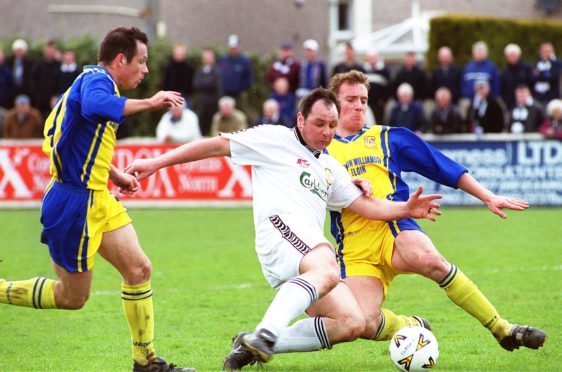 Alan Hercher (centre, in white) in action for Clach.