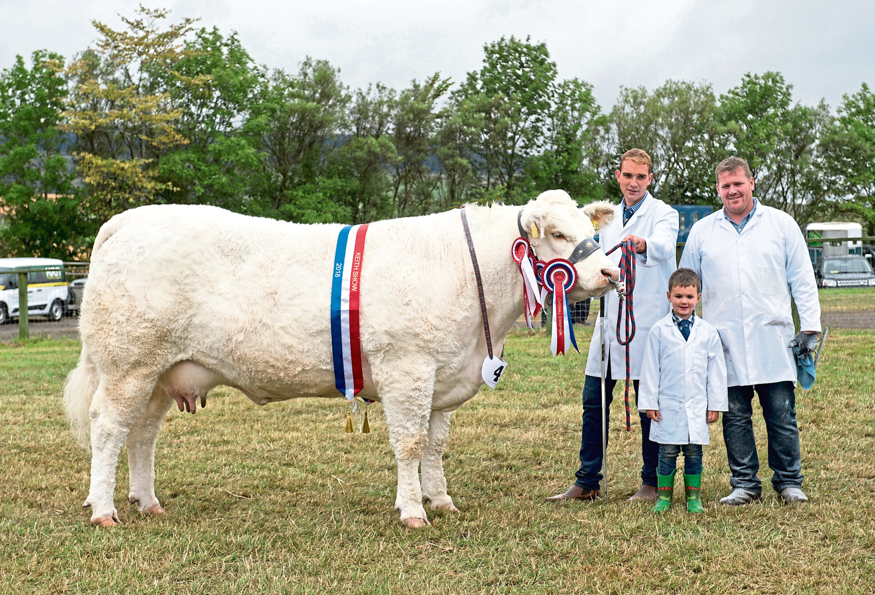 Sandy Hunter with the champion cow and Garry Patterson and his son Olly.