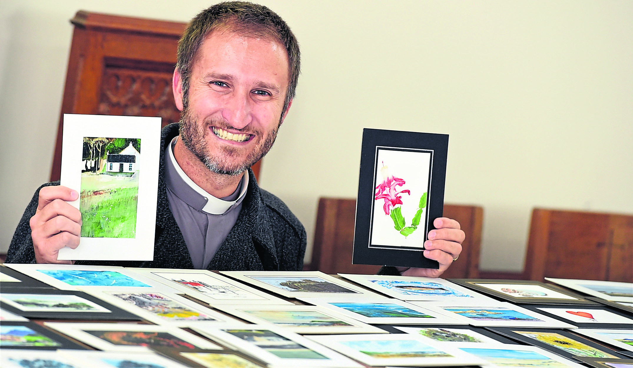 The rev Dr Will Stalder with the paintings on sale with a fundraising art fair at the Methlick Parish church, Methlick. 
Picture by Jim Irvine.