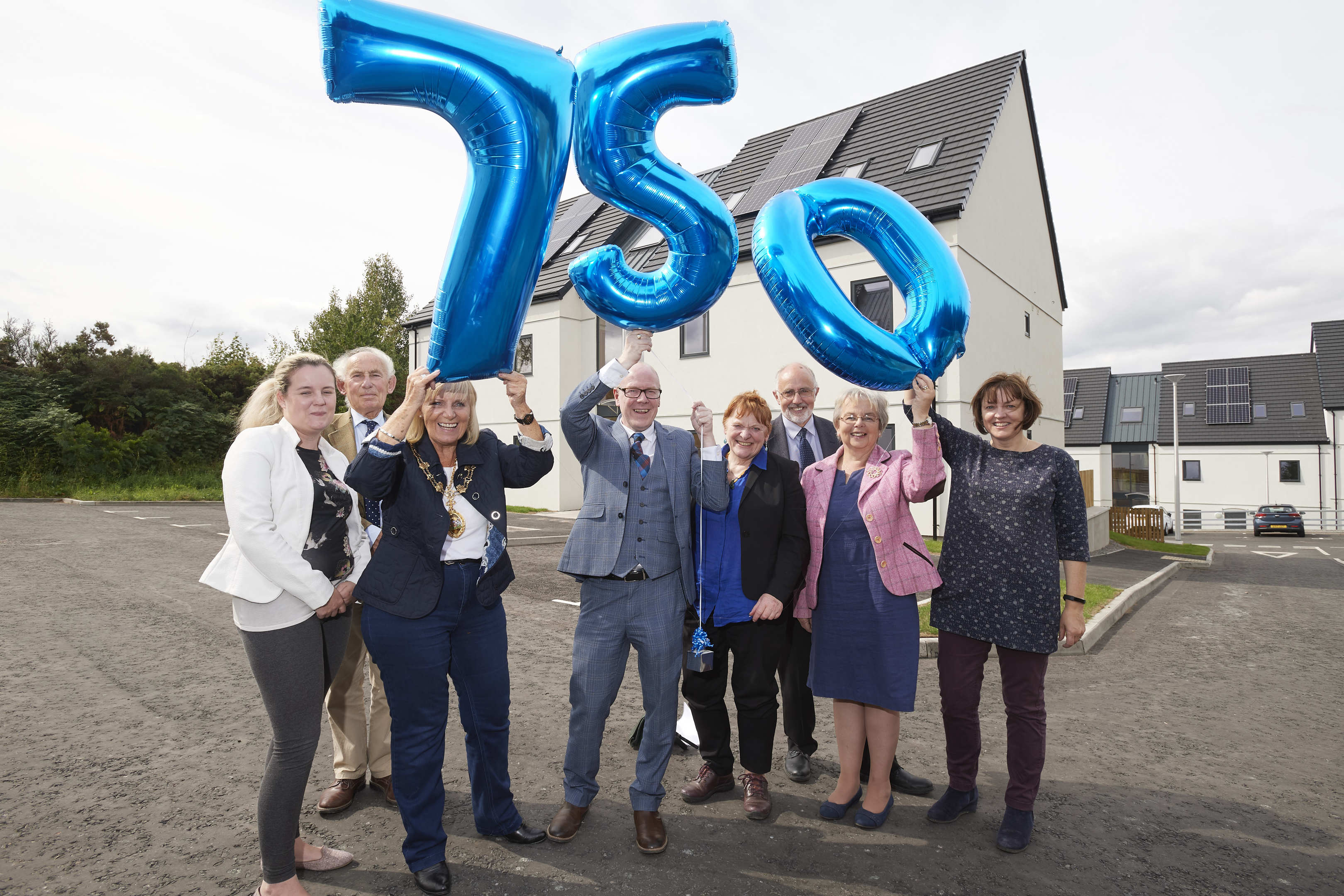 Housing minister Kevin Stewart MSP celebrates with local councillors in Inverness at the 750th build