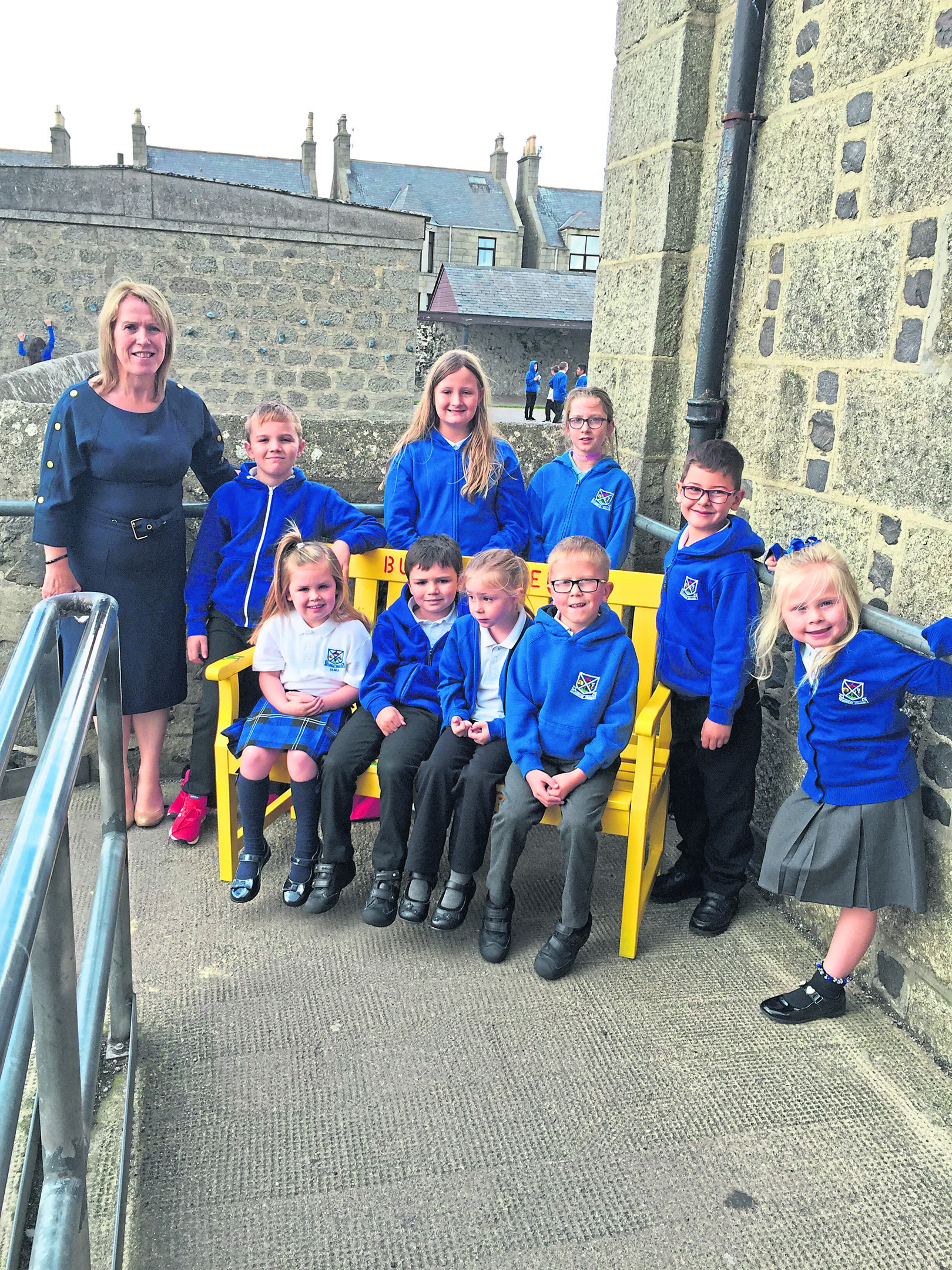 Mrs. Birnie, head teacher at St. Andrew's, along with some of the pupils receiving the bench.