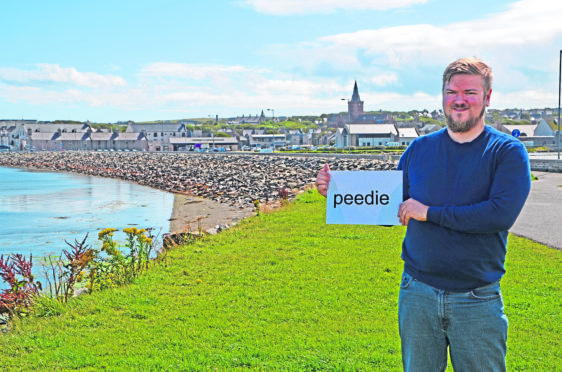 Ryan Kemp is to test Orcadians on their dialect. Here he holds a sign with the Scots word for “small”.