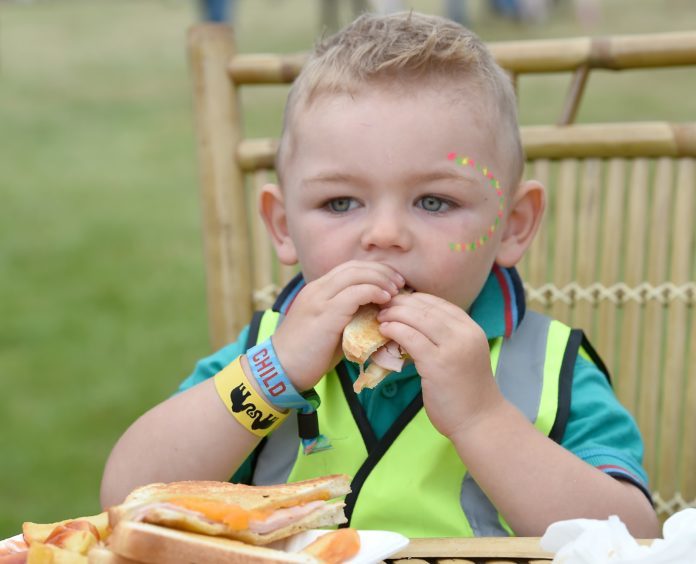 Picture by SANDY McCOOK  3rd August '18
Belladrum 2018 Friday night.
Two year old Archie Wallace of Nairn tucks in to his tea on Friday night.